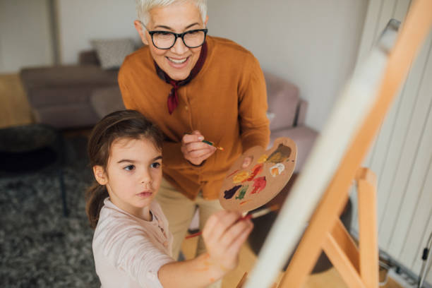 femme et sa petite-fille peinture - artist child artists canvas indoors photos et images de collection