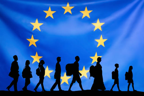Silhouette Of Refugees People With Luggage Walking In A Row