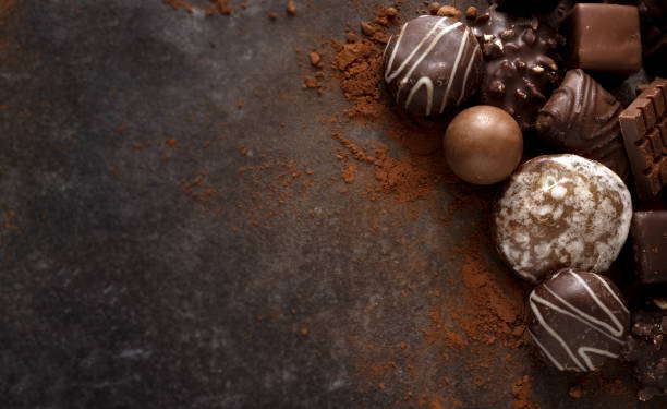 biscotti al cioccolato natalizio e praline su una lastra di pietra scura con ampio spazio di copia, vista ad alto angolo dall'alto - pralina di cioccolato foto e immagini stock