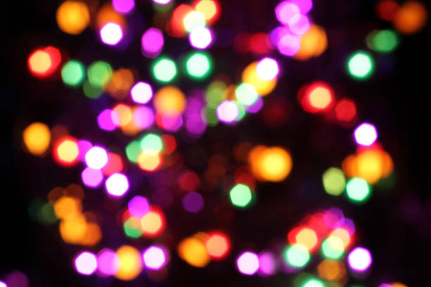 Blurred yellow, white, red, purple and green lights on black background