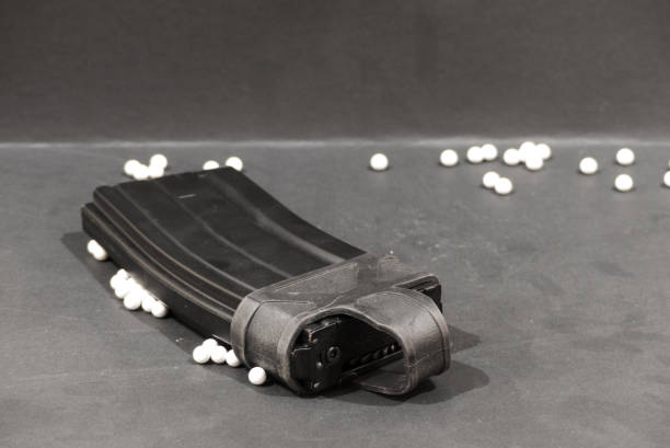 istock airsoft pistol with bb bullets on black glossy surface, hi cap, bbloader 1079295672