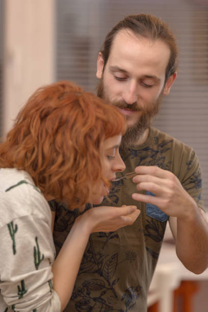 istock Young women tasting dish she cooked with her boyfriend. 1079295696