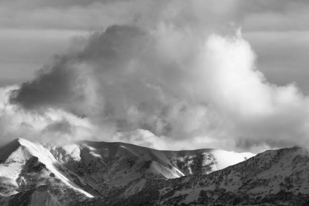 istock Snowy mountains with forest and sunlight cloudy sky 1079305102