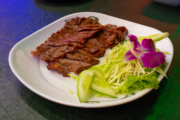 istock Grilled beef on a white plate with the sauce and vegetables. 1079326938