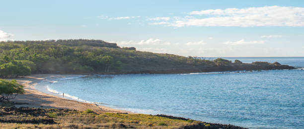 панорамный вид на пляж hulopo'e на ланаи, с человеком, идущего вдоль surf - lanai стоковые фото и изображения