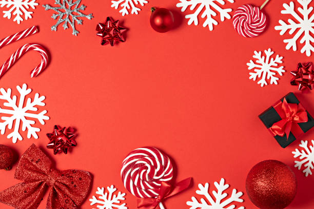 Christmas handmade gift boxes decorated with red paper, candy, star, white snowflakes on red background top view. Merry christmas greeting card. Winter xmas holiday theme. Happy New Year