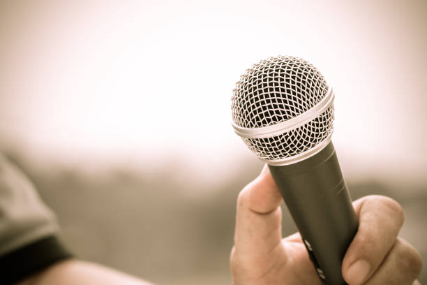 Microphones on abstract blurred of speech in seminar room or front speaking conference hall, blure light people in event meeting convention hall background, close up shot for copy space, Vintage tone