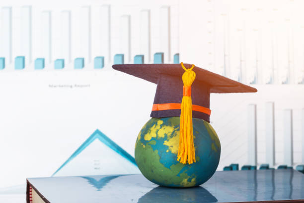 istock Education Graduate study business international concept: Graduation cap on top Earth globe model map with marketing graph report on screen classroom. Ideas for MBA learning success, Back to School 1079413414