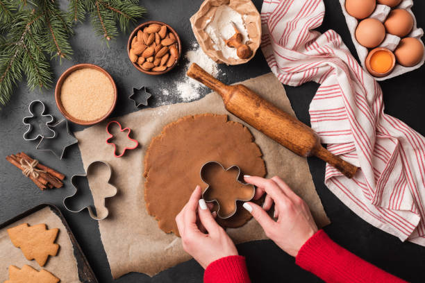 Baking gingerbread cookies, cookie cutter and woman hands