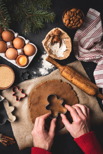 istock Male hands cutting gingerbread man cookies 1079433414
