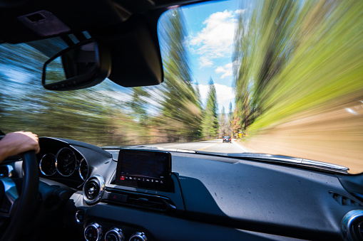Blurry Scenery from a Speeding Car by Yosemite. I captured this image by keeping the camera extremely still in the passenger seat, with a wide angle lens. The affect was to capture the movement of the car while keeping the interior sharp.