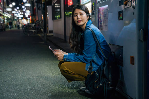 istock woman crouch down by the vending machine 1079444890