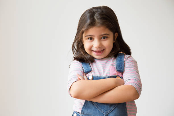 istock Cheerful Hispanic child standing with crossed arms 1079447080