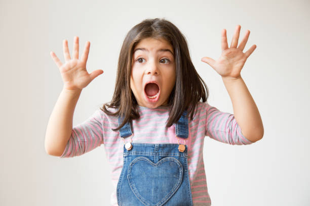 istock Shocked Hispanic child shouting and holding hands up 1079447186