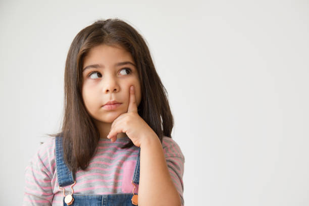 istock Cute thoughtful Latin child looking up and touching chin 1079447222