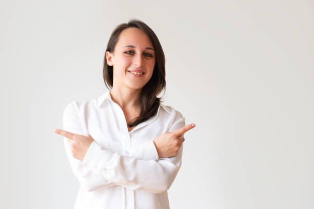 istock Beautiful young woman pointing at copy space 1079454992