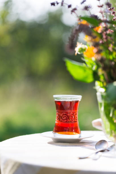 istock Black tea in pear shaped glass on table in garden under sunlight, summer outdoors, copy space 1079482724