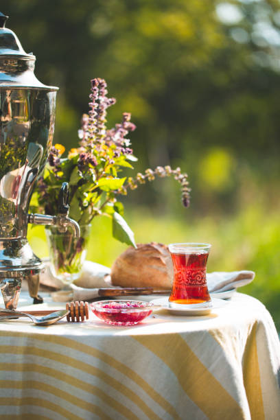 istock Tea set ceremony in garden setting, summer outdoors breakfast with fresh bread and rose jam and samovar 1079482740