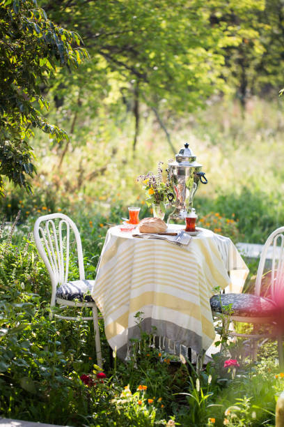 istock Tea set ceremony in garden setting, summer outdoors breakfast with fresh bread and rose jam and samovar 1079482940