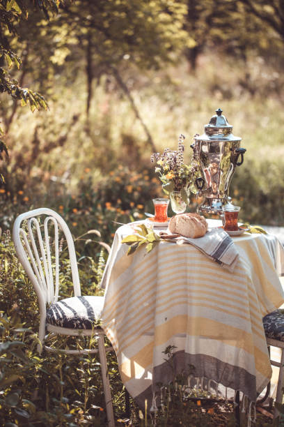 istock Tea set ceremony in garden setting, summer outdoors breakfast with fresh bread and rose jam and samovar 1079483510