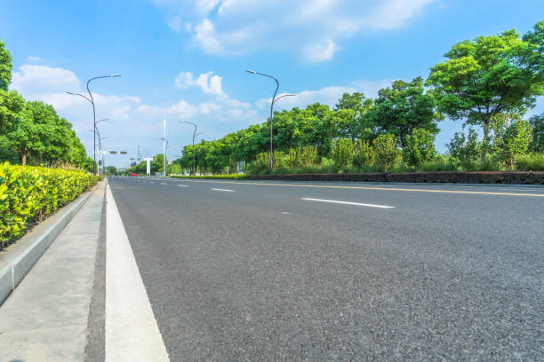 istock Asphalt road and green trees under blue sky 1079485642
