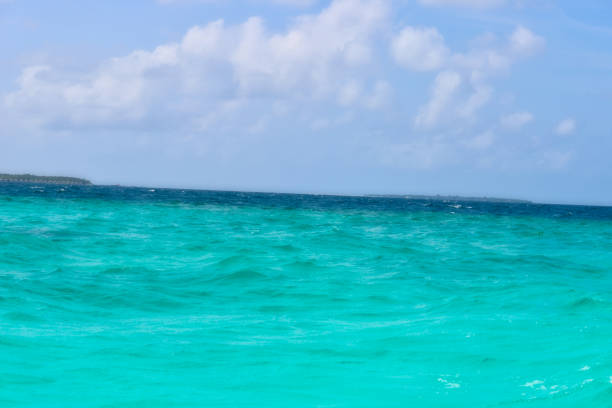 This photo shows the turquoise waters of the Indian Ocean on a slightly cloudy day and on the left in the background you can still see a small island