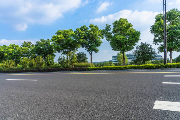 istock Asphalt road and green trees under blue sky 1079487298