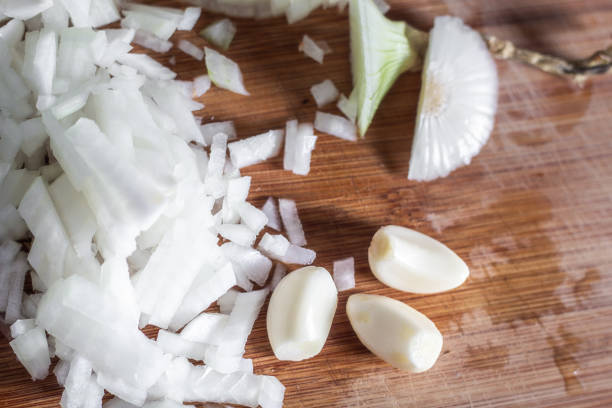 Garlic cloves and sliced onion on cutting board