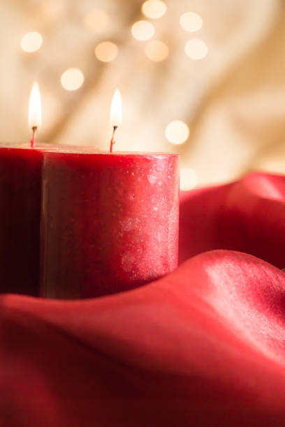 istock Lit red candles , on red wavy fabric and golden background with bokeh. 1079511192