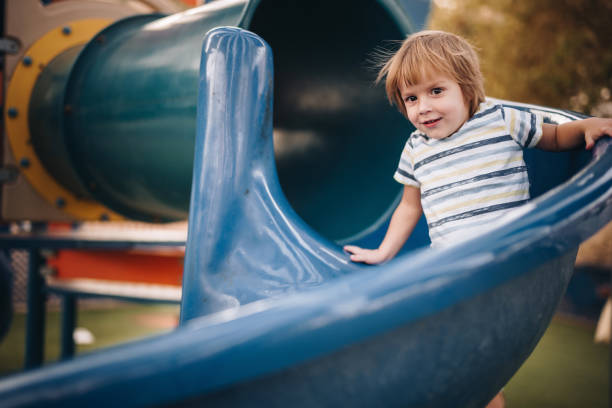 istock Cute little boy having fun while sliding on the playground. 1079553292