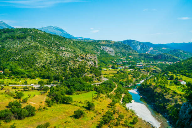 Podgorica, Montenegro - July 26, 2016: Podgorica   view from the train as it passes through Montenegro's mountains, river, trees, rock mountains and houses can be seen on the background