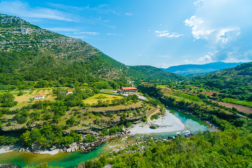Podgorica, Montenegro - July 26, 2016: Podgorica   view from the train as it passes through Montenegro's mountains, river, trees, rock mountains and houses can be seen on the background