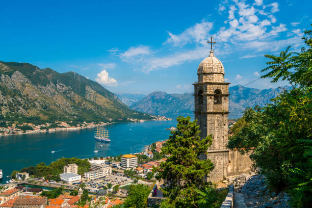 Kotor Cruise Port and Lake and Bell tower, Montenegro, Europe Kotor, Montenegro - July 24, 2016: view showing Kotor Cruise Port and Lake, bell tower,  rock mountains, trees, street cars, buildings and houses can be seen on the background montenegro stock pictures, royalty-free photos & images