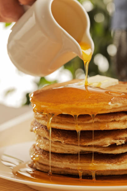 istock Chef pouring maple syrup over stacked pancakes 1079555852