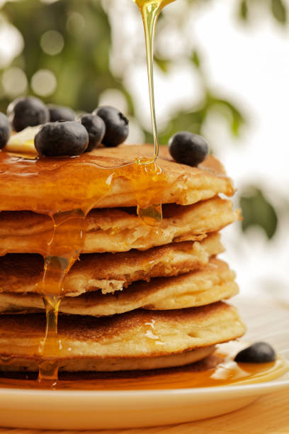 istock Chef pouring maple syrup over stacked pancakes 1079556244