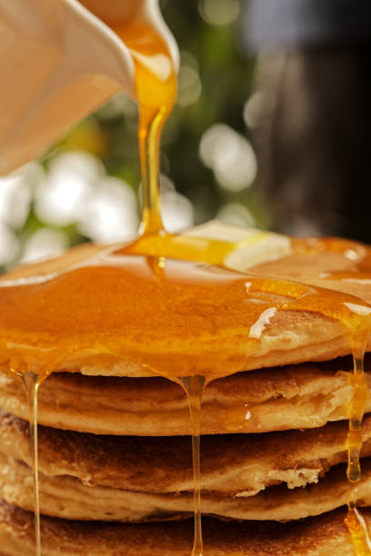 istock Chef pouring maple syrup over stacked pancakes 1079557038