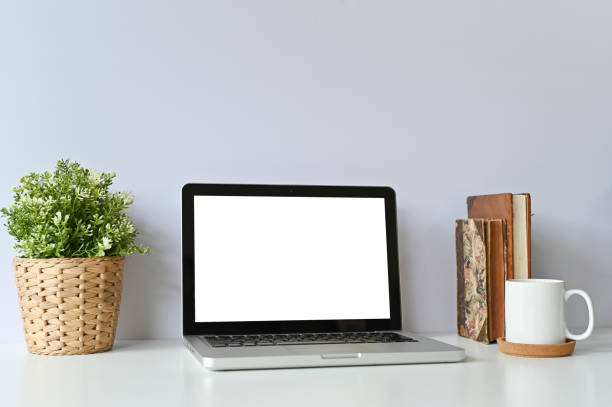 istock Mockup laptop computer, books, coffee and plant decoration on office table. 1079561516