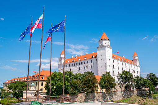 Bratislava, Slovakia - July 5, 2016: view showing Bratislava Castle, trees and flags can be seen on the background
