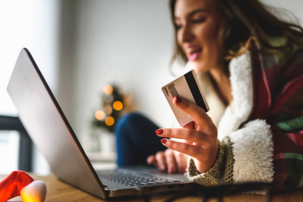 istock Young woman buying online at home  for winter holidays using laptop computer 1079573396
