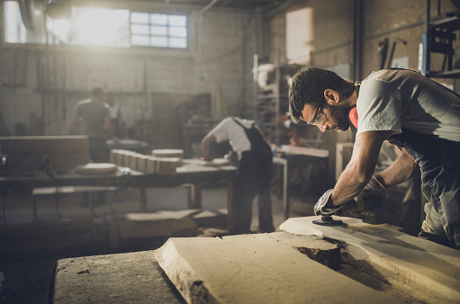 Guy Using A Sander Young Man Using Sander While Working On A Piece Of Wood In A Workshop ...