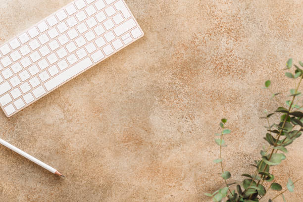 istock Top view on a home workspace with white keyboard, pencil and plant. Copy space, flat lay. 1079577996