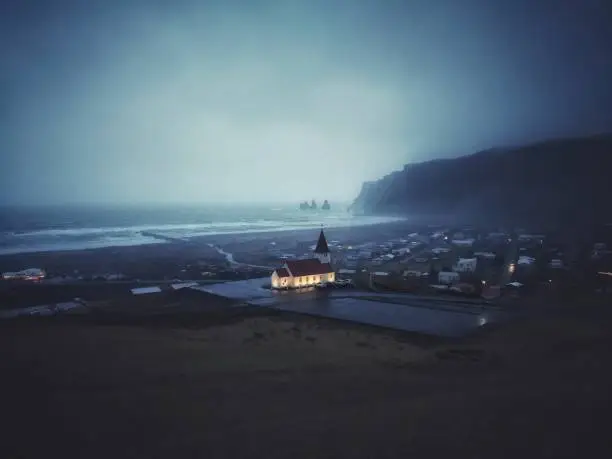 Stormy nightshot of the white chapel in Vik, Iceland.