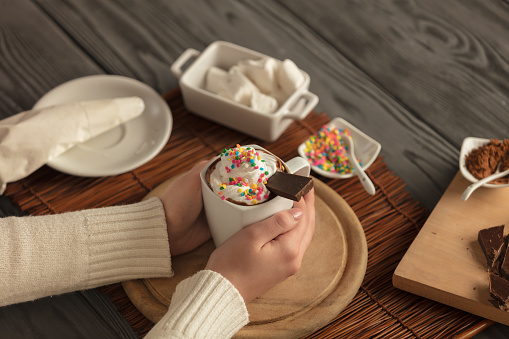 Hands With A Cup Of Nicely Decorated Hot Chocolate In A Winter Atmosphere. NOTE: Shallow Depth Of Field