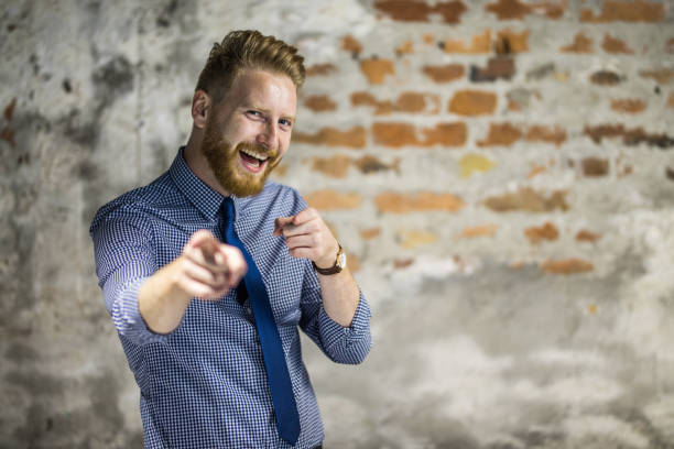 Young businessman with fists isolated on black background