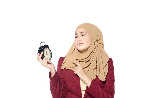 time management and punctuality at work concept, beautiful hijab women holding vintage alarm clock isolated on white background