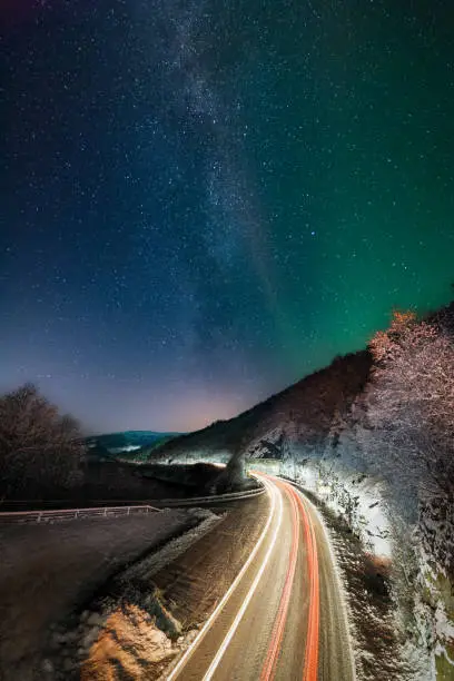 Night shot of moving cars and the milky way in the background. Image from Trengsel bridge in Sørfold, Norway.