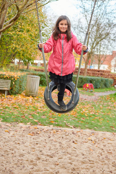 Pakistan immigrants in Denmark. Girl having fun at the playground swinging.
