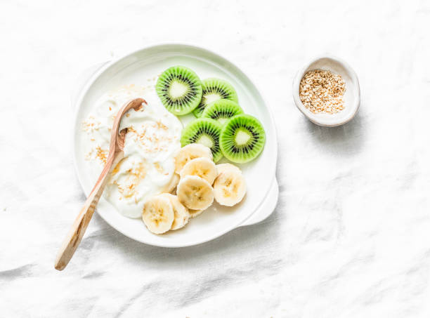 istock Healthy diet breakfast - greek yogurt with honey and fruit on a light background, top view. Copy space 1079617080