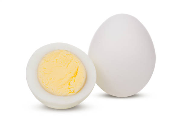 istock Two boiled whole and sliced eggs isolated on white background 1079621512