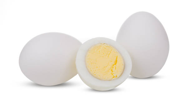 istock Two boiled whole and sliced eggs isolated on white background 1079621524